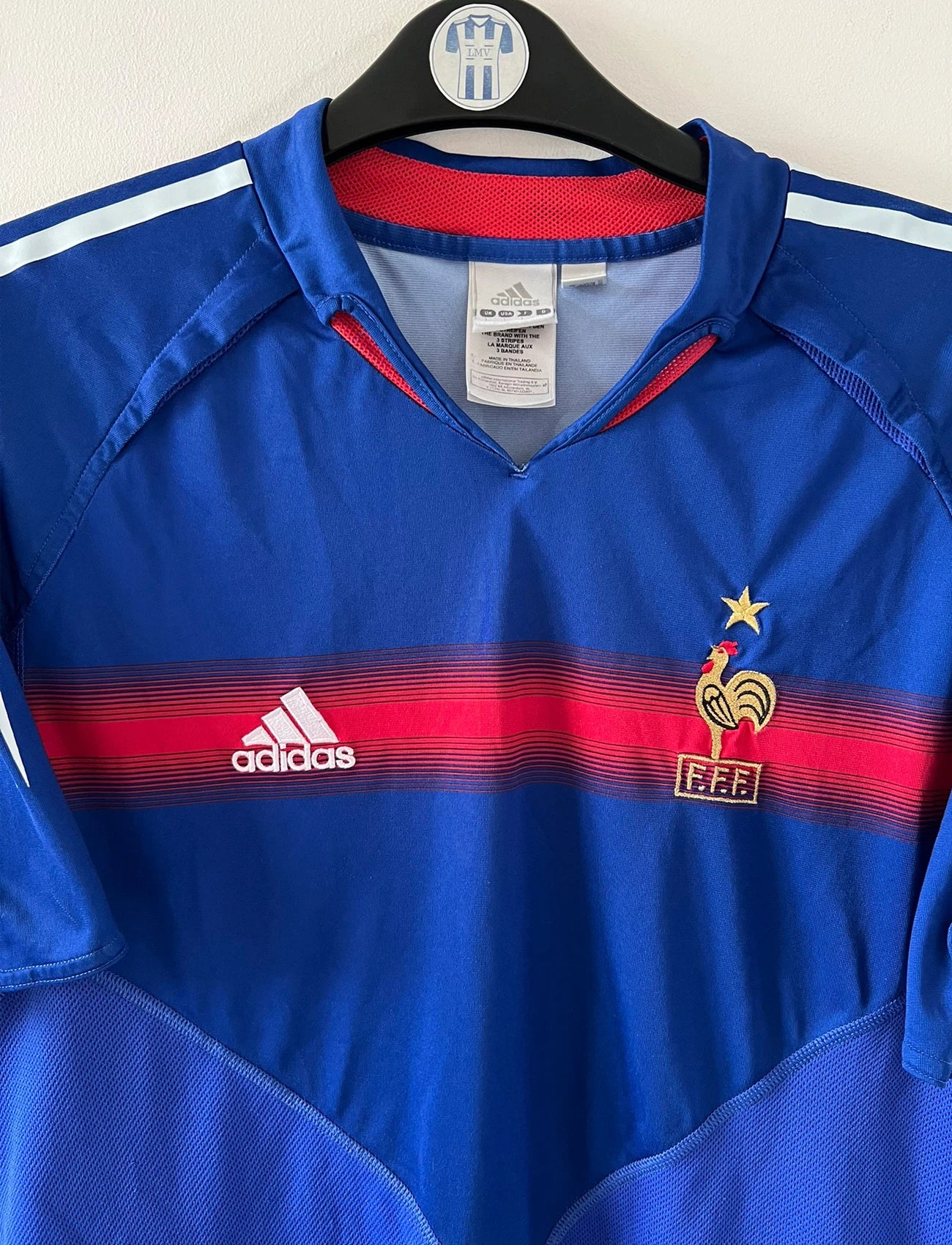 Maillot de foot vintage domicile bleu de l'Equipe de France 2004. On peut retrouver l'équipementier Adidas. Le maillot est floqué du numéro 10 Zinedine Zidane. Il s'agit d'un maillot authentique d'époque.