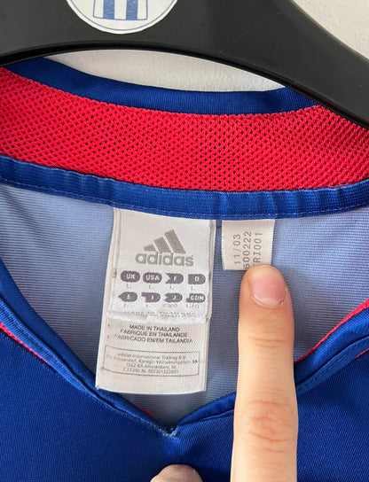 Maillot de foot vintage domicile bleu de l'Equipe de France 2004. On peut retrouver l'équipementier Adidas. Le maillot est floqué du numéro 10 Zinedine Zidane. Il s'agit d'un maillot authentique d'époque.