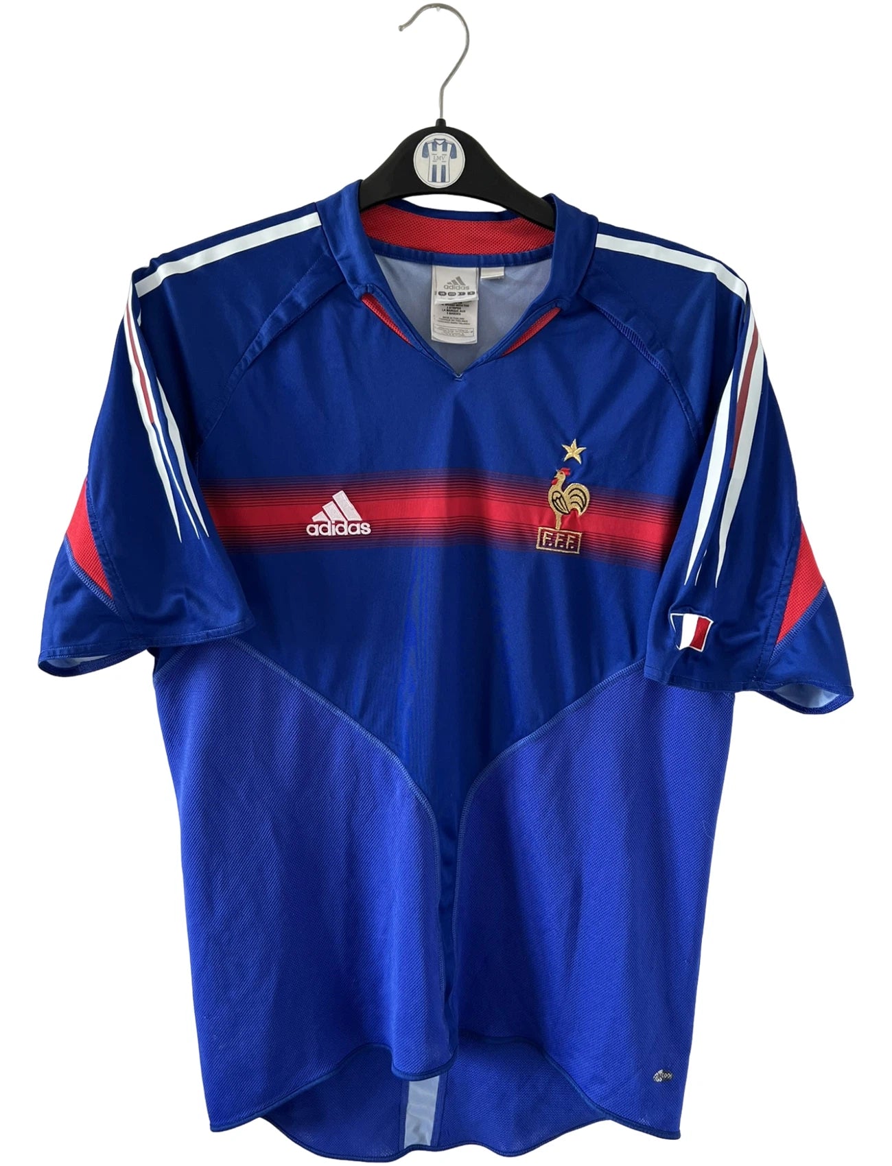 Maillot de foot vintage domicile bleu de l'Equipe de France 2004. On peut retrouver l'équipementier Adidas. Le maillot est floqué du numéro 10 Zinedine Zidane. Il s'agit d'un maillot authentique d'époque.
