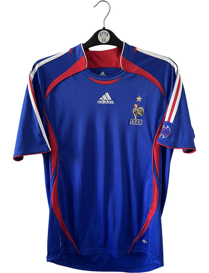 Maillot de foot vintage domicile bleu de l'équipe de france 2006. On peut retrouver l'équipementier Adidas. Il s'agit d'un maillot authentique d'époque.