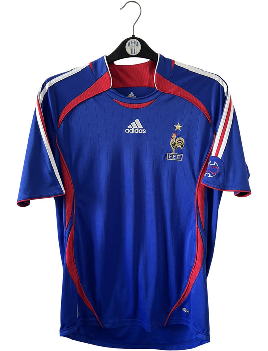 Maillot de foot vintage domicile bleu de l'équipe de france 2006. On peut retrouver l'équipementier Adidas. Il s'agit d'un maillot authentique d'époque.