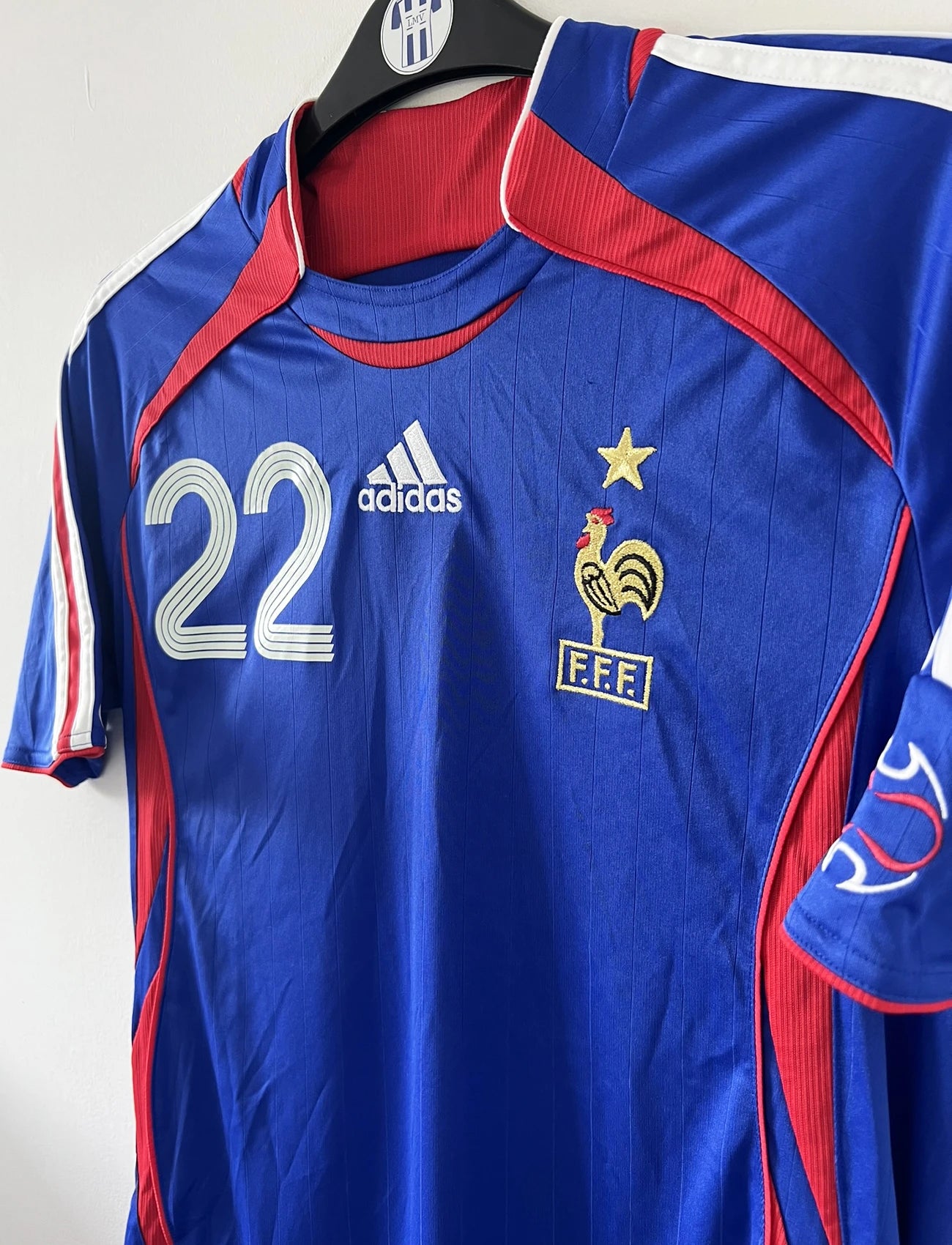 Maillot de foot vintage domicile de l'équipe de france 2006. On peut retrouver l'équipementier adidas. Le maillot est floqué du numéro 22 Franck Ribery. Il s'agit d'un maillot authentique d'époque comportant les numéros 740126
