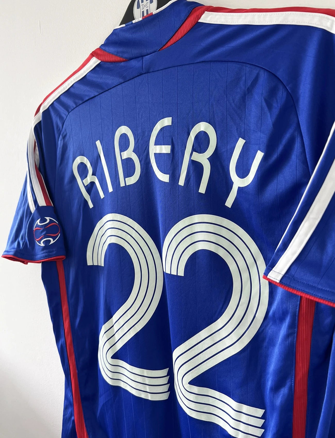 Maillot de foot vintage domicile de l'équipe de france 2006. On peut retrouver l'équipementier adidas. Le maillot est floqué du numéro 22 Franck Ribery. Il s'agit d'un maillot authentique d'époque comportant les numéros 740126