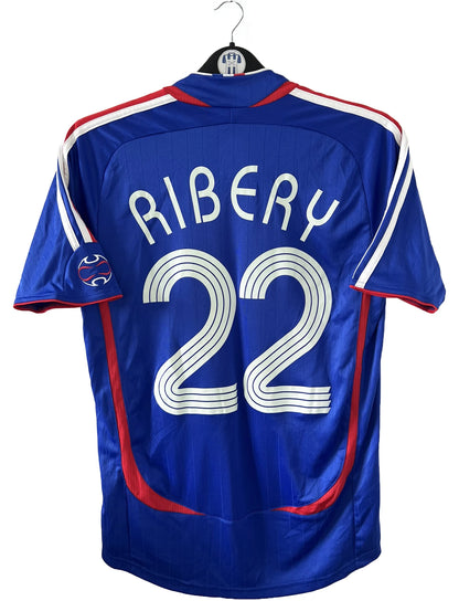 Maillot de foot vintage domicile de l'équipe de france 2006. On peut retrouver l'équipementier adidas. Le maillot est floqué du numéro 22 Franck Ribery. Il s'agit d'un maillot authentique d'époque comportant les numéros 740126