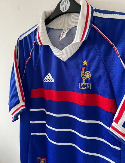 Maillot foot vintage domicile equipe de france 1998 bleu blanc et rouge. On peut retrouver l'équipementier adidas. Ils 'agit d'un maillot authentique d'époque floqué Zinedine Zidane