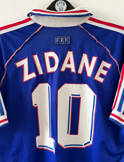Maillot foot vintage domicile equipe de france 1998 bleu blanc et rouge. On peut retrouver l'équipementier adidas. Ils 'agit d'un maillot authentique d'époque floqué Zinedine Zidane