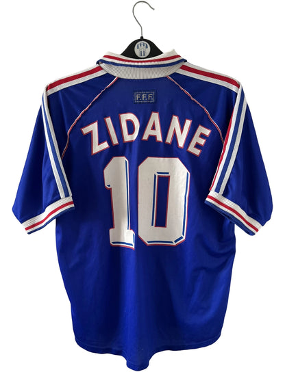Maillot foot vintage domicile equipe de france 1998 bleu blanc et rouge. On peut retrouver l'équipementier adidas. Ils 'agit d'un maillot authentique d'époque floqué Zinedine Zidane