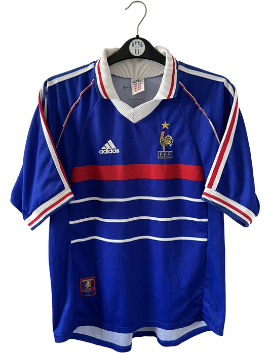 Maillot foot vintage domicile equipe de france 1998 bleu blanc et rouge. On peut retrouver l'équipementier adidas. Ils 'agit d'un maillot authentique d'époque floqué Zinedine Zidane