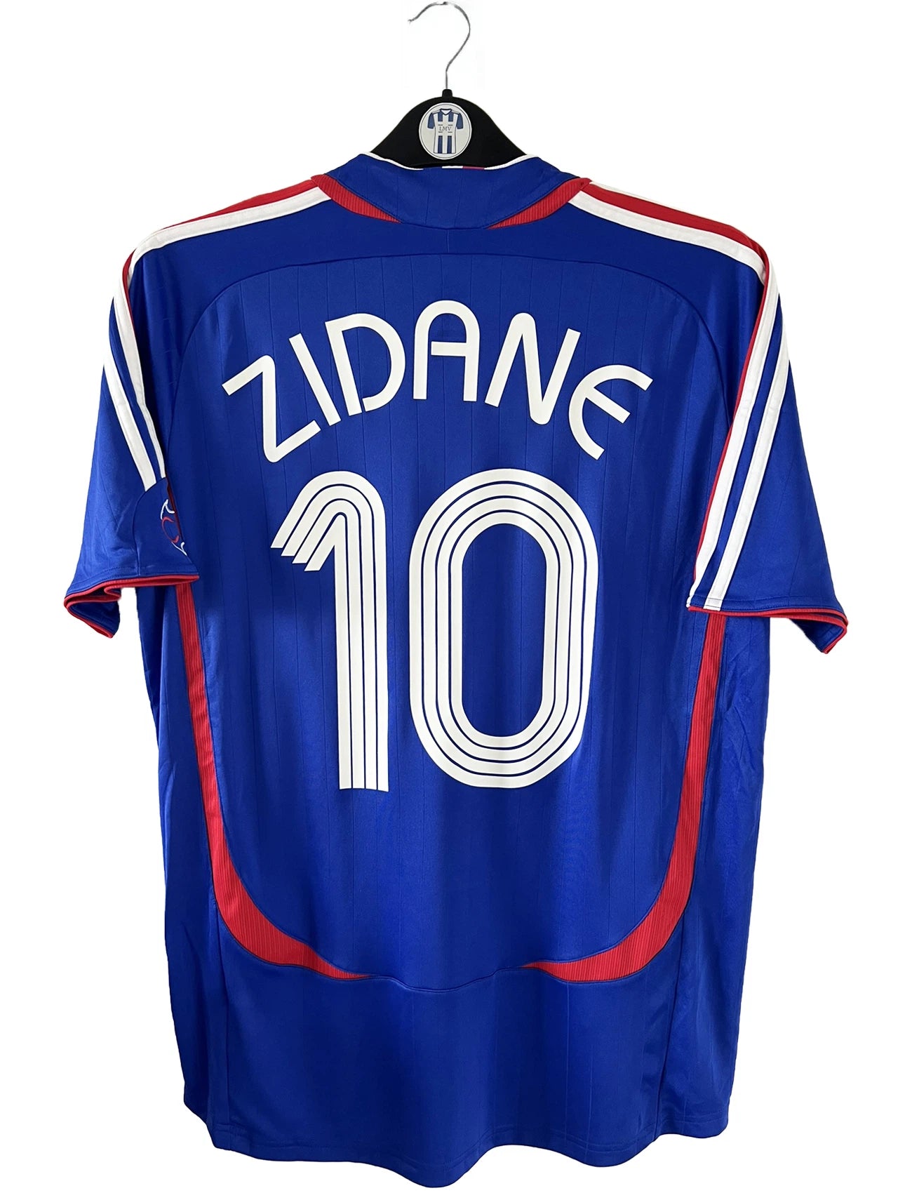 Maillot de foot vintage domicile bleu de l'équipe de france 2006. On peut retrouver l'équipementier adidas. Le maillot est floqué du numéro 10 Zinedine Zidane. Il s'agit d'un maillot authentique comportant l'étiquette 740126.