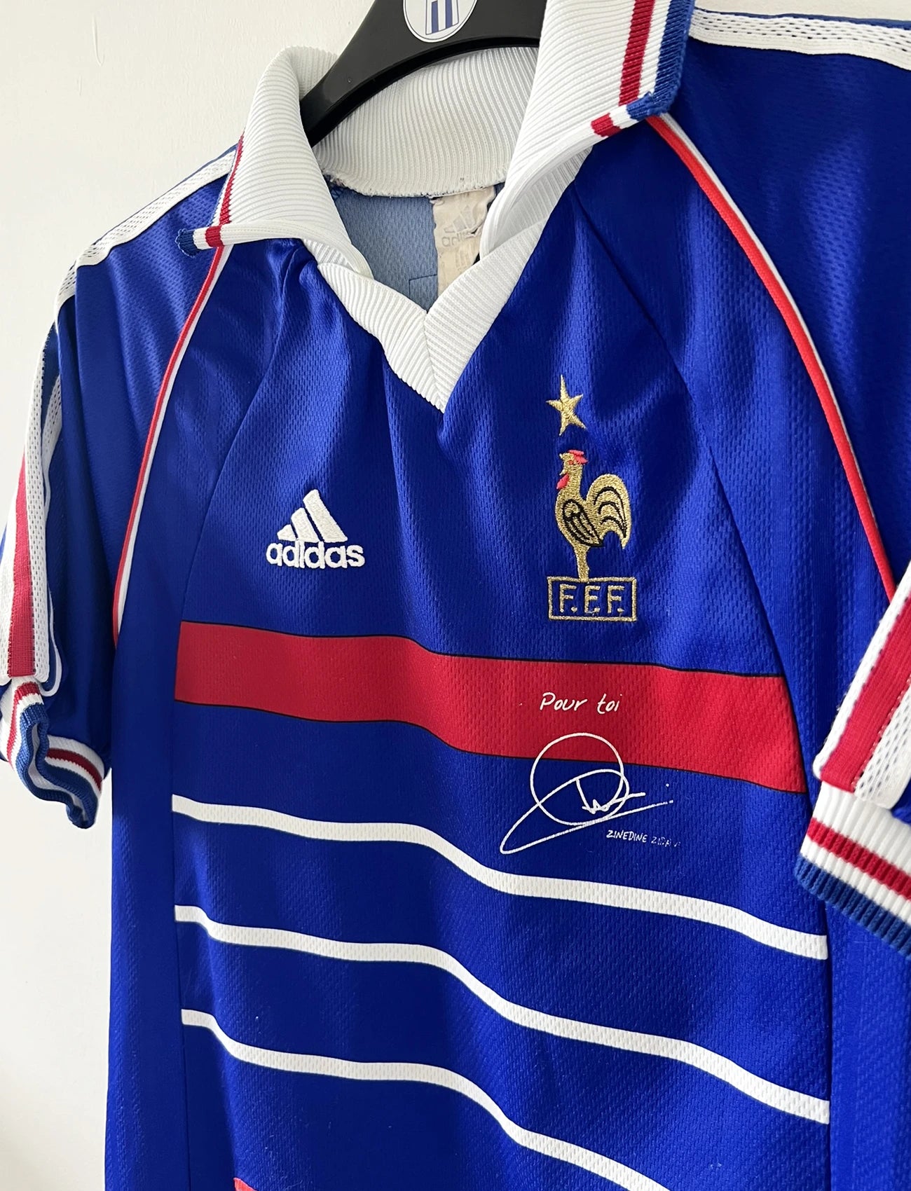 Maillot de foot vintage domicile bleu blanc et rouge de l'équipe de france lors de la coupe du monde 1998. On peut retrouver l'équipementier adidas. Le maillot est floqué du numéro 10 zinedine zidane. Il s'agit d'un maillot authentique d'époque.