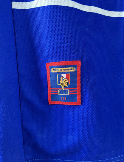 Maillot de foot vintage domicile bleu blanc et rouge de l'équipe de france lors de la coupe du monde 1998. On peut retrouver l'équipementier adidas. Le maillot est floqué du numéro 10 zinedine zidane. Il s'agit d'un maillot authentique d'époque.