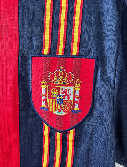 Maillot de foot vintage domicile rouge de l'Espagne 1996. On peut retrouver l'équipementier Adidas. Il s'agit d'un maillot authentique d'époque.