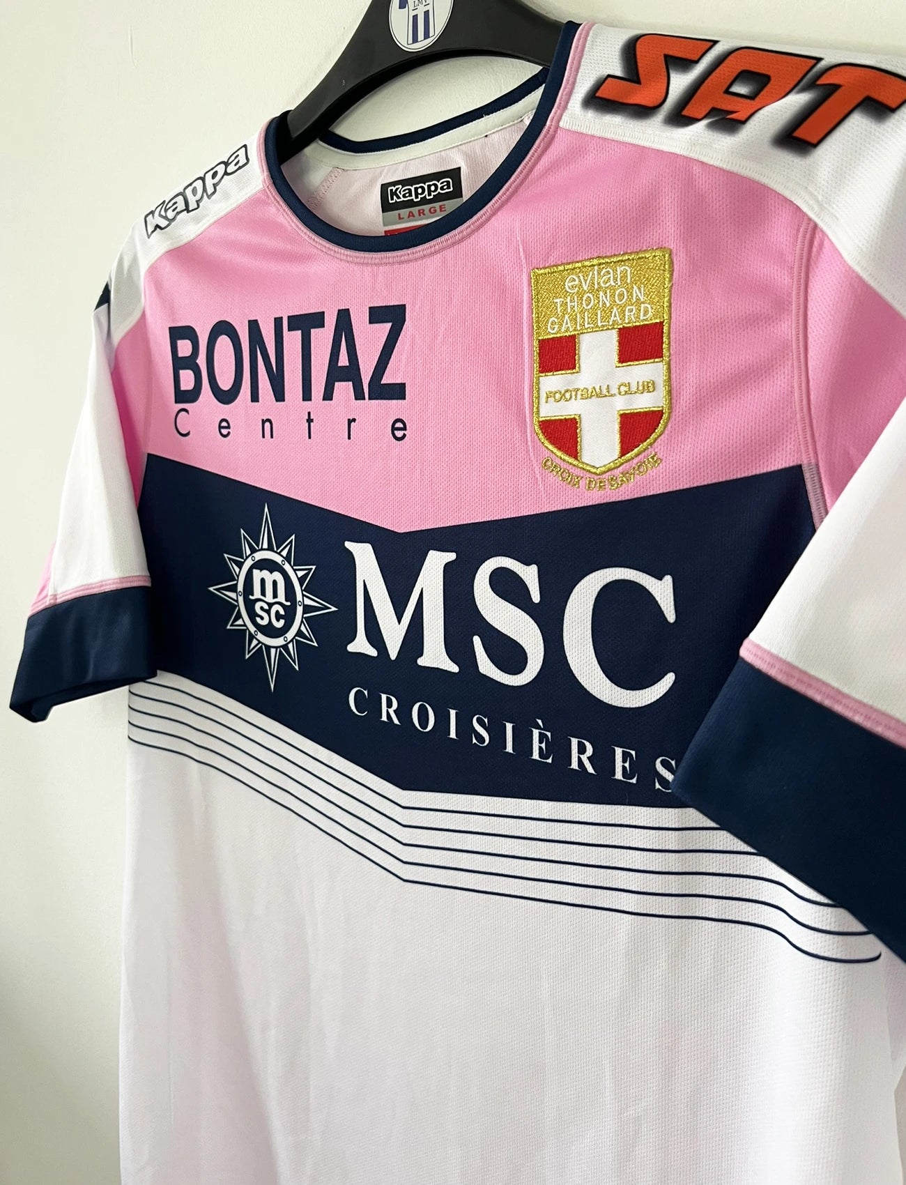 Maillot de foot domicile vintage rose et blanc de l'Evian Thonon Gaillard de la saison 2015/2016. On peut retrouver l'équipementier kappa et le sponsor msc. Il s'agit d'un maillot authentique d'époque.