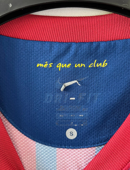 Maillot de foot vintage domicile rouge et bleu du FC Barcelone 2011/2012. On peut retrouver l'équipementier Nike et le sponsor Qatar Foundation. Le maillot est floqué du numéro 10 Lionel Messi. Il s'agit d'un maillot authentique d'époque