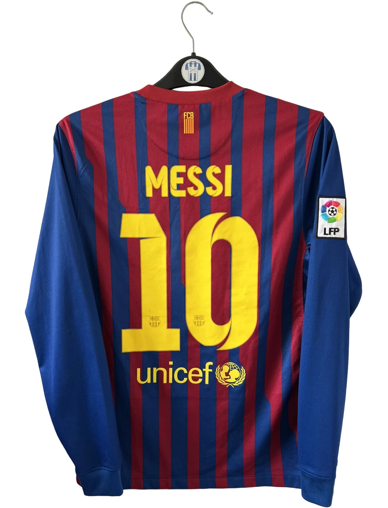 Maillot de foot vintage domicile rouge et bleu du FC Barcelone 2011/2012. On peut retrouver l'équipementier Nike et le sponsor Qatar Foundation. Le maillot est floqué du numéro 10 Lionel Messi. Il s'agit d'un maillot authentique d'époque