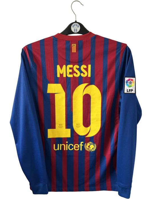 Maillot de foot vintage domicile rouge et bleu du FC Barcelone 2011/2012. On peut retrouver l'équipementier Nike et le sponsor Qatar Foundation. Le maillot est floqué du numéro 10 Lionel Messi. Il s'agit d'un maillot authentique d'époque
