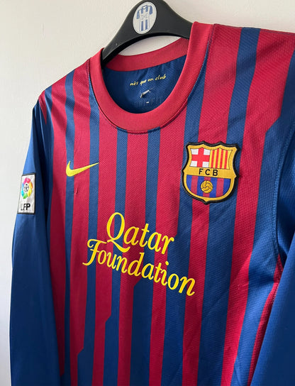 Maillot de foot vintage domicile rouge et bleu du FC Barcelone 2011/2012. On peut retrouver l'équipementier Nike et le sponsor Qatar Foundation. Le maillot est floqué du numéro 10 Lionel Messi. Il s'agit d'un maillot authentique d'époque
