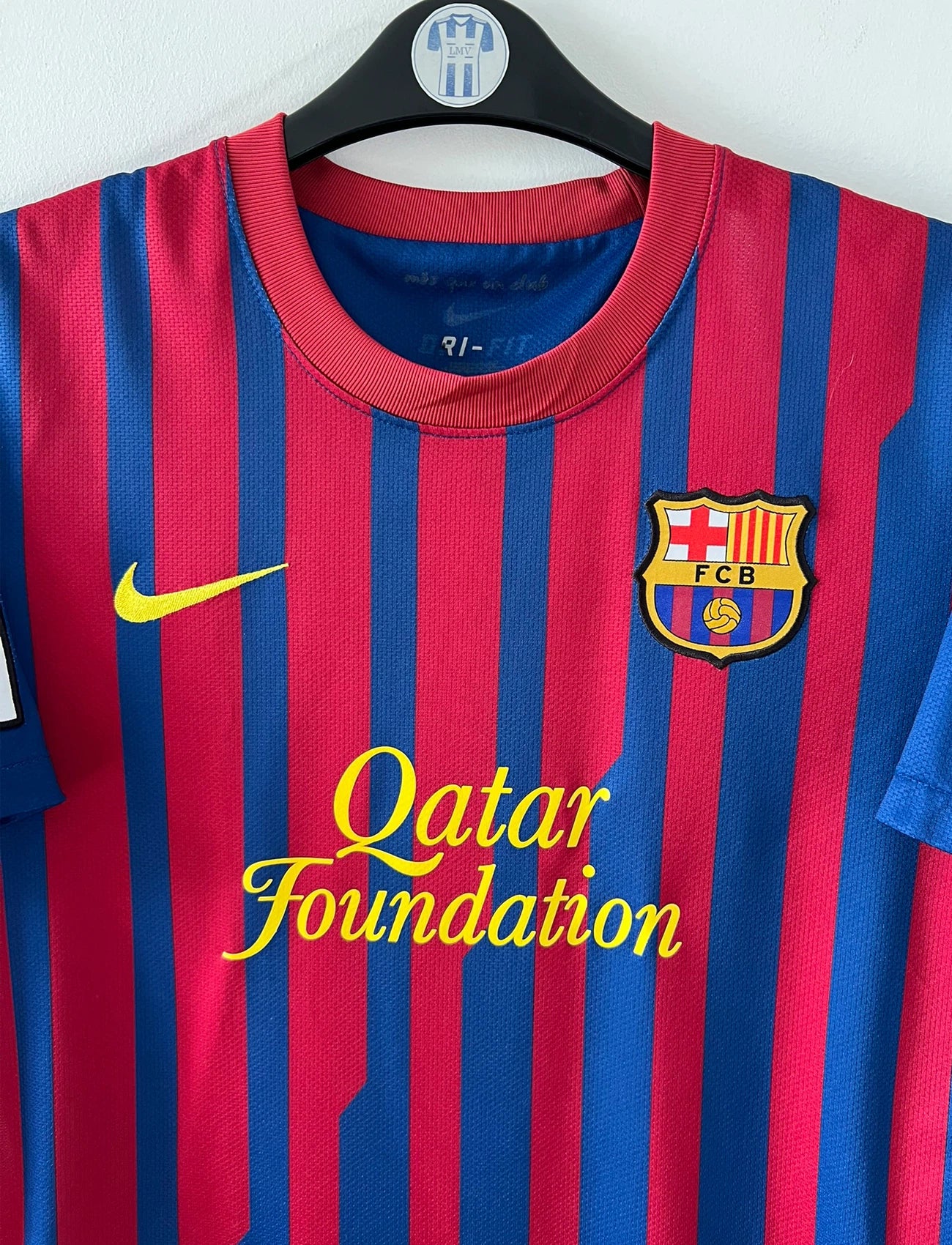 Maillot de foot vintage domicile rouge et bleu du FC Barcelone 2011/2012. On peut retrouver l'équipementier Nike et le sponsor Qatar Foundation. Le maillot est floqué du numéro 6 Xavi. Il s'agit d'un maillot authentique d'époque.
