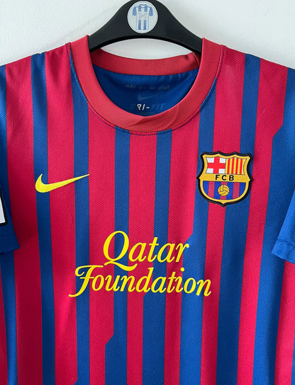 Maillot de foot vintage domicile rouge et bleu du FC Barcelone 2011/2012. On peut retrouver l'équipementier Nike et le sponsor Qatar Foundation. Le maillot est floqué du numéro 6 Xavi. Il s'agit d'un maillot authentique d'époque.