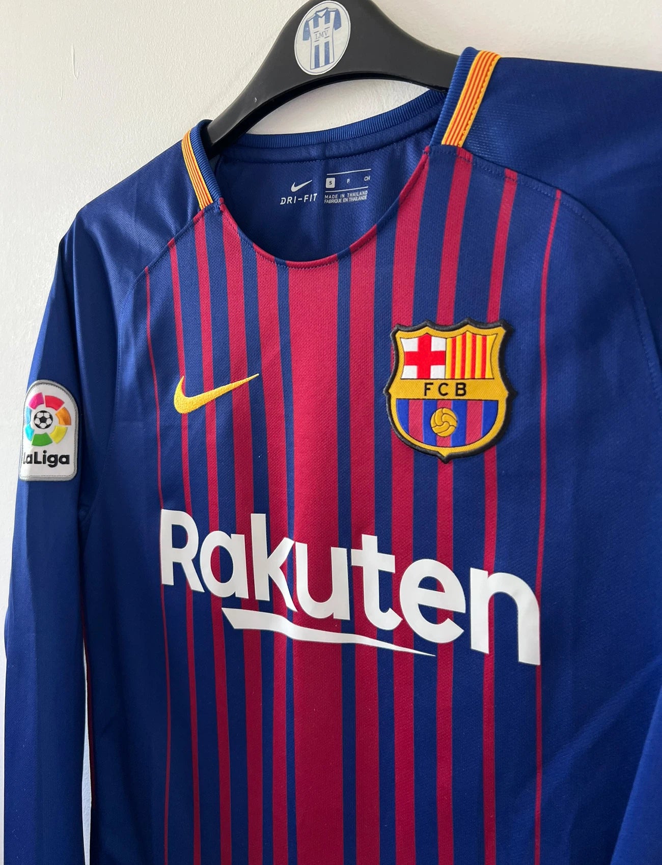 Maillot de foot vintage domicile rouge et bleu du FC Barcelone 2017/2018. On peut retrouver l'équipementier Nike et le sponsor Rakuten. Le maillot est floqué du numéro 10 Lionel Messi. Il s'agit d'un maillot authentique d'époque.