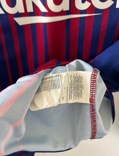Maillot de foot vintage domicile rouge et bleu du FC Barcelone 2017/2018. On peut retrouver l'équipementier Nike et le sponsor Rakuten. Le maillot est floqué du numéro 10 Lionel Messi. Il s'agit d'un maillot authentique d'époque.
