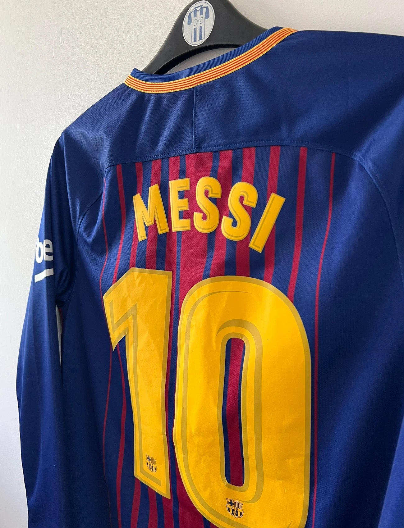 Maillot de foot vintage domicile rouge et bleu du FC Barcelone 2017/2018. On peut retrouver l'équipementier Nike et le sponsor Rakuten. Le maillot est floqué du numéro 10 Lionel Messi. Il s'agit d'un maillot authentique d'époque.