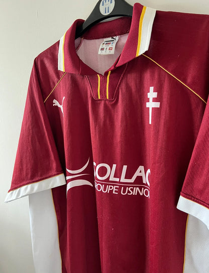 Maillot de foot vintage domicile rouge et blanc du FC Metz saison 1998/1999. On peut retrouver l'équipementier Puma et le sponsor Sollac. Il s'agit d'un maillot authentique d'époque.