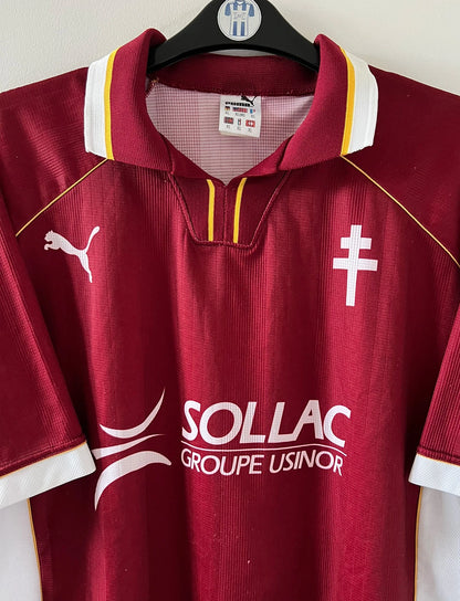 Maillot de foot vintage domicile rouge et blanc du FC Metz saison 1998/1999. On peut retrouver l'équipementier Puma et le sponsor Sollac. Il s'agit d'un maillot authentique d'époque.