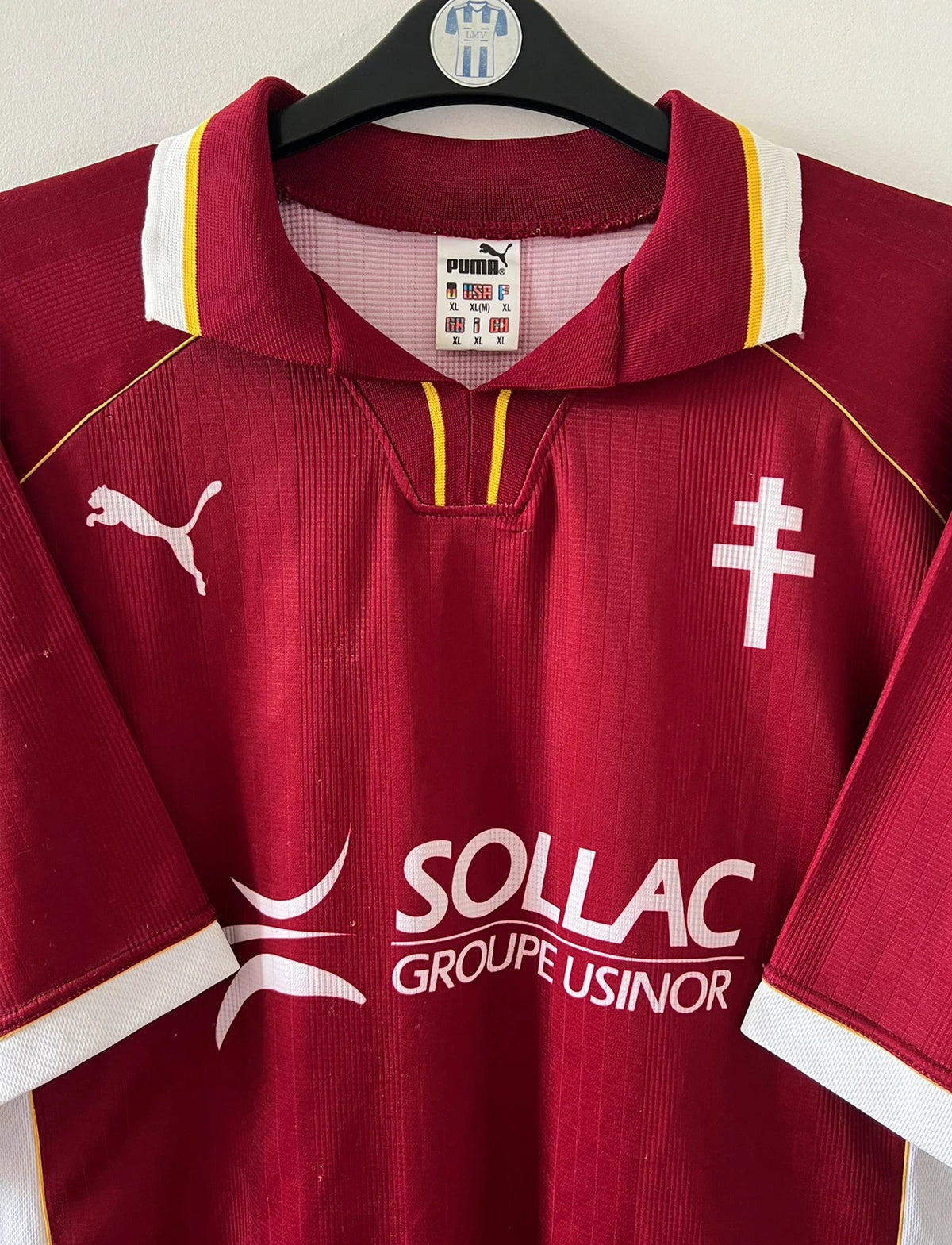 Maillot de foot vintage domicile rouge et blanc du FC Metz de la saison 1998/1999. On peut retrouver l'équipementier Puma et le sponsor Sollac. Le maillot est floqué du numéro 14 Geoffray Toyes. Il s'agit d'un maillot authentique d'époque.