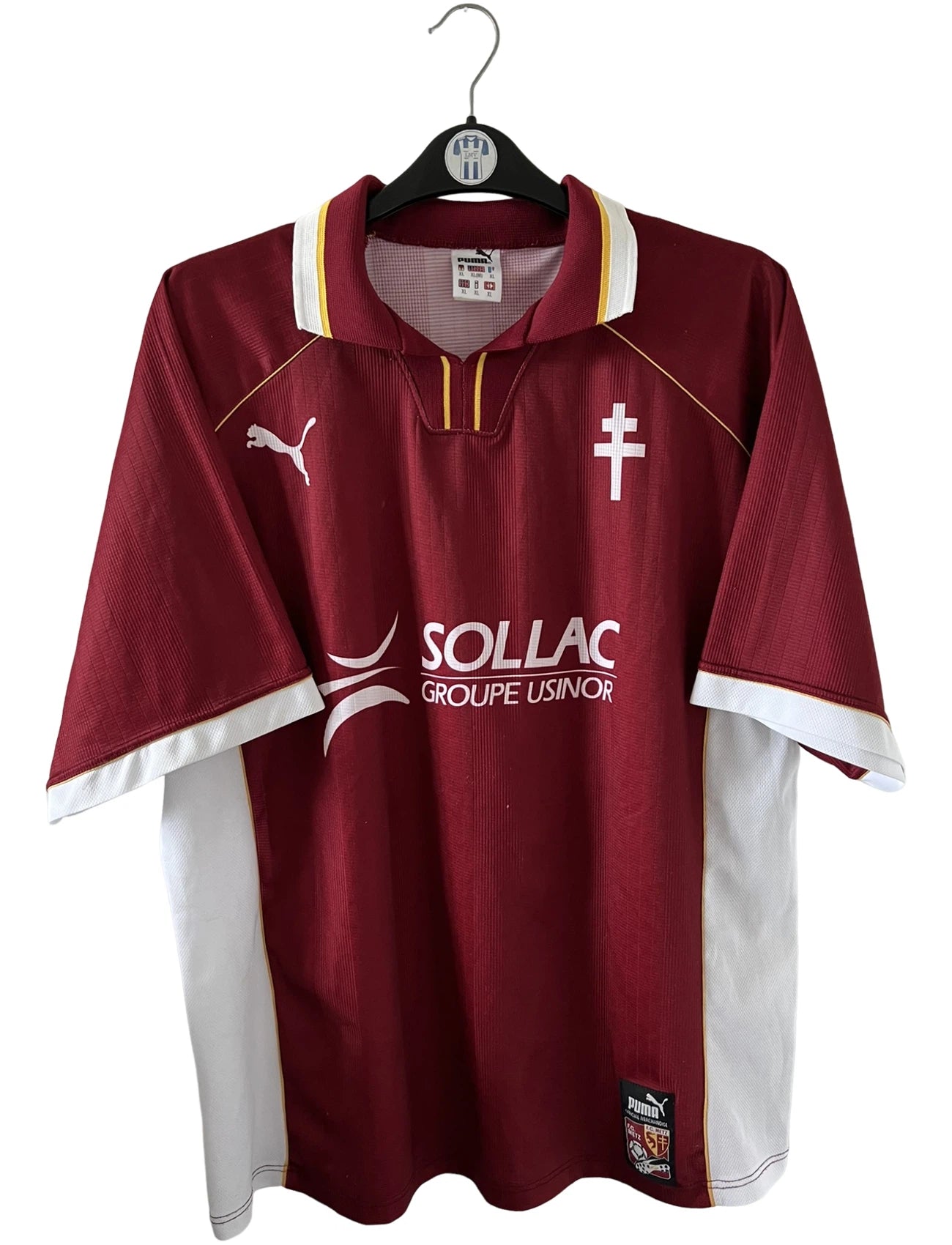 Maillot de foot vintage domicile rouge et blanc du FC Metz saison 1998/1999. On peut retrouver l'équipementier Puma et le sponsor Sollac. Il s'agit d'un maillot authentique d'époque.