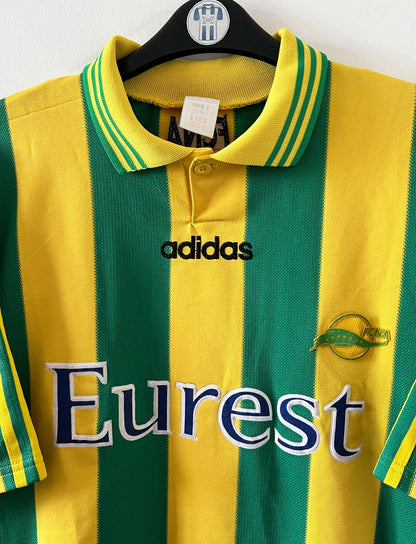 Maillot de foot vintage domicile jaune et vert du FC Nantes 1996/1997. On peut retrouver l'équipementier Adidas et le sponsor Eurest. Il s'agit d'un maillot authentique d'époque.