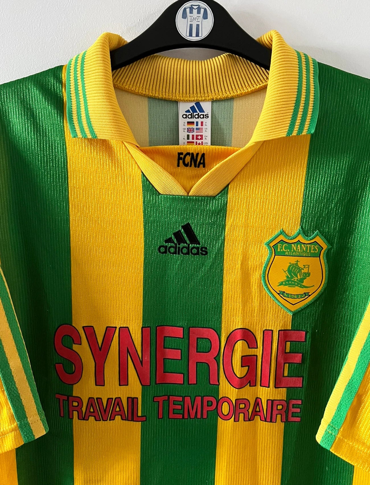 Maillot foot vintage domicile jaune et vert du FC Nantes 1998/2000. On peut retrouver l'équipementier Adidas et le sponsor Synergie. Il s'agit d'un maillot authentique d'époque.