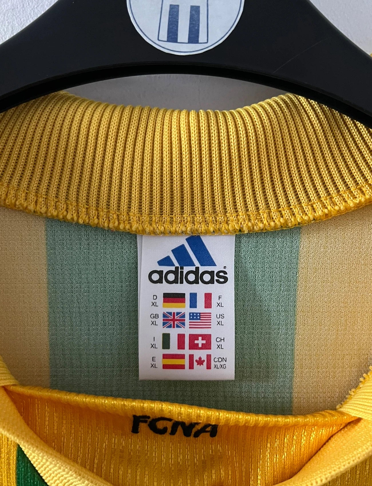 Maillot foot vintage domicile jaune et vert du FC Nantes 1998/2000. On peut retrouver l'équipementier Adidas et le sponsor Synergie. Il s'agit d'un maillot authentique d'époque.