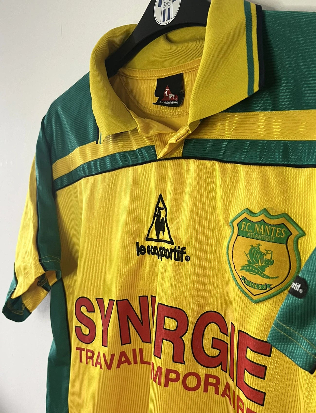 Maillot de foot vintage domicile du FC Nantes de la saison 2001/2002. On peut retrouver l'équipementier Le Coq Sportif et le sponsor Synergie. Il s'agit d'un maillot authentique d'époque.