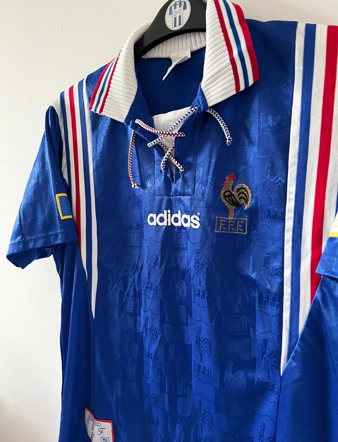 Maillot de foot vintage domicile bleu de l'Equipe de France 1996. On peut retrouver l'équipementier Adidas. Il s'agit d'un maillot authentique d'époque.