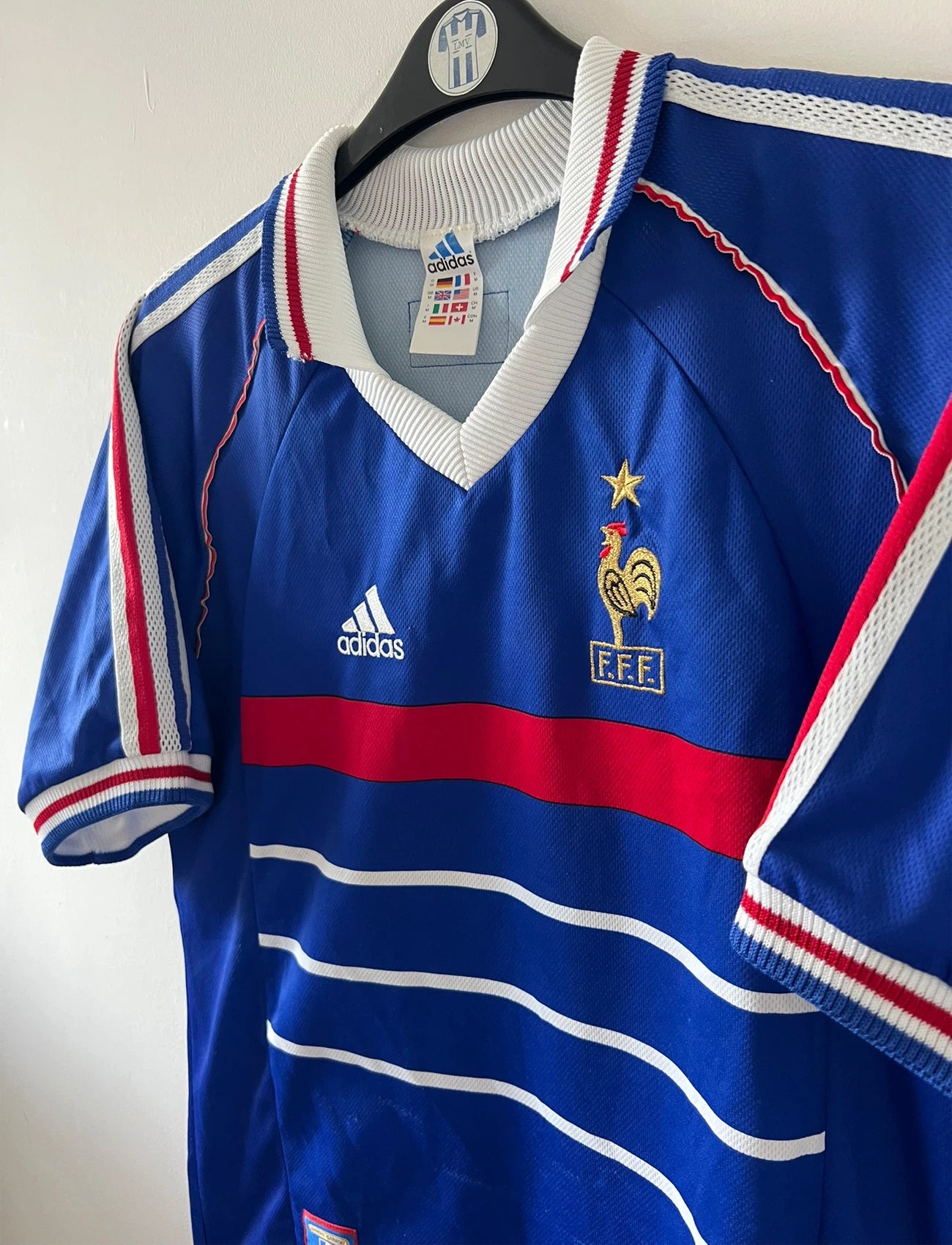 Maillot de foot vintage domicile bleu de l'équipe de France 1998. On peut retrouver l'équipementier Adidas. Il s'agit d'un maillot authentique d'époque.