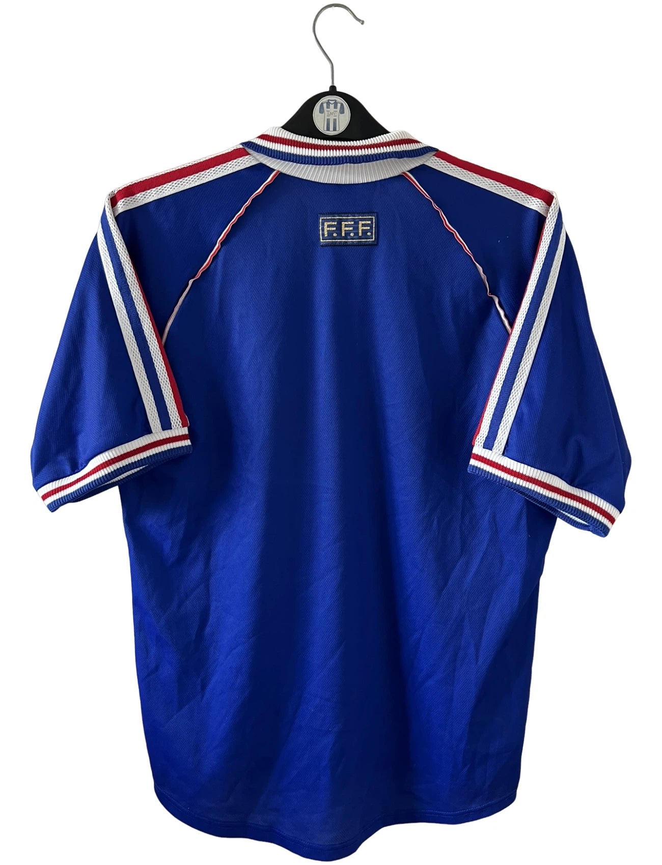 Maillot de foot vintage domicile bleu de l'équipe de France 1998. On peut retrouver l'équipementier Adidas. Il s'agit d'un maillot authentique d'époque.