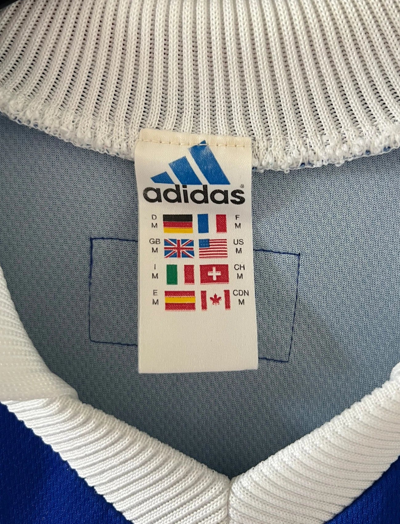 Maillot de foot vintage domicile bleu de l'équipe de France 1998. On peut retrouver l'équipementier Adidas. Il s'agit d'un maillot authentique d'époque.
