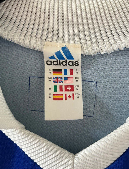 Maillot de foot vintage domicile bleu de l'équipe de France 1998. On peut retrouver l'équipementier Adidas. Il s'agit d'un maillot authentique d'époque.