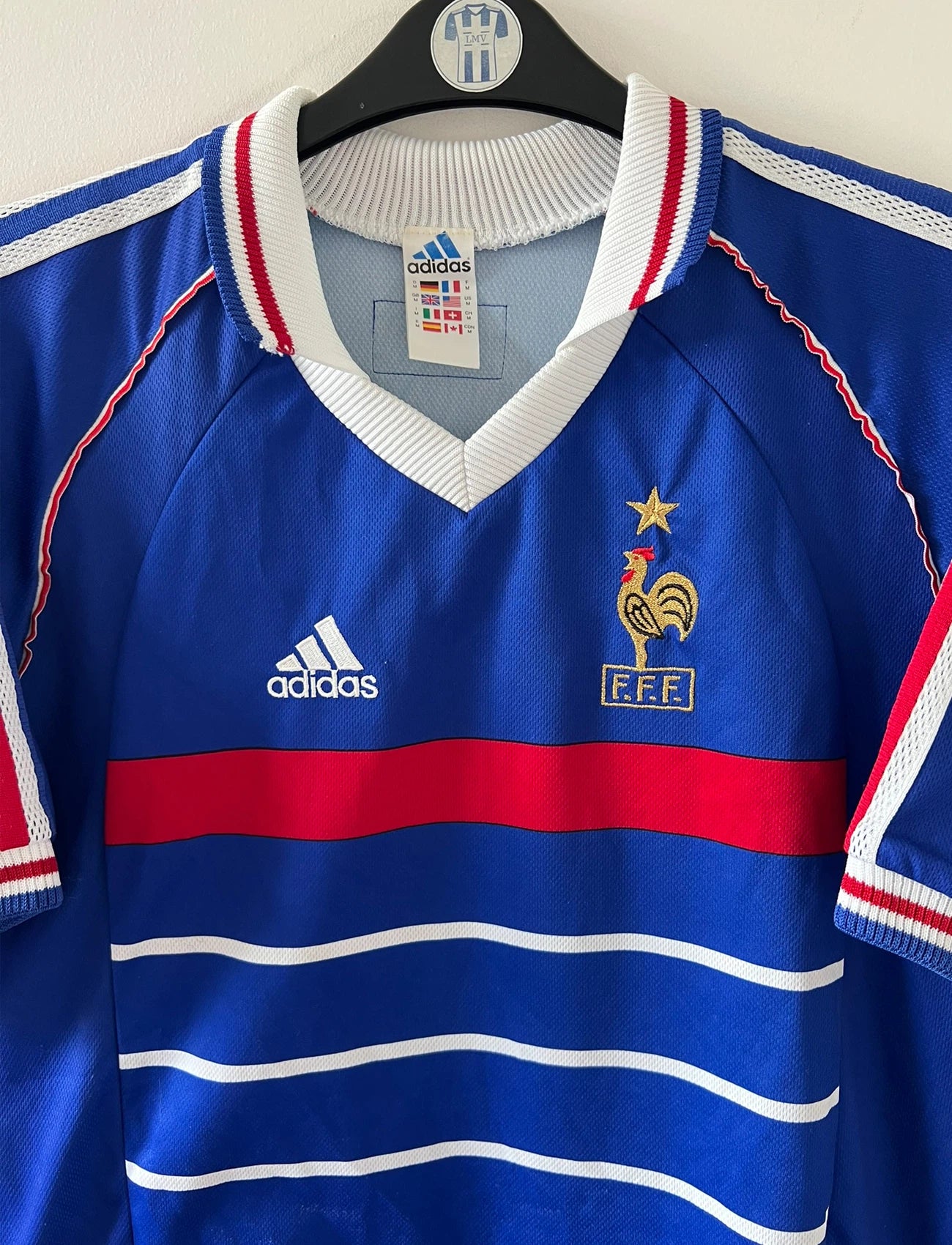 Maillot de foot vintage domicile bleu de l'équipe de France 1998. On peut retrouver l'équipementier Adidas. Il s'agit d'un maillot authentique d'époque.