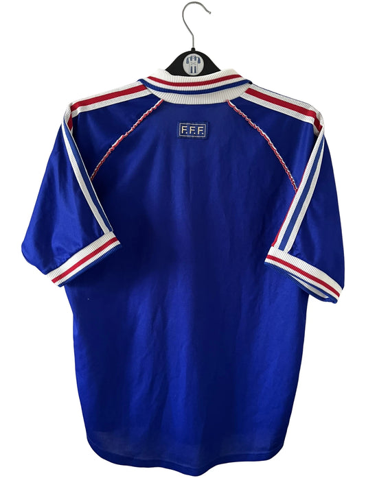 Maillot de foot vintage domicile bleu blanc et rouge de l'équipe de france 1998. On peut retrouver l'équipementier Adidas. Il s'agit d'un maillot authentique d'époque.
