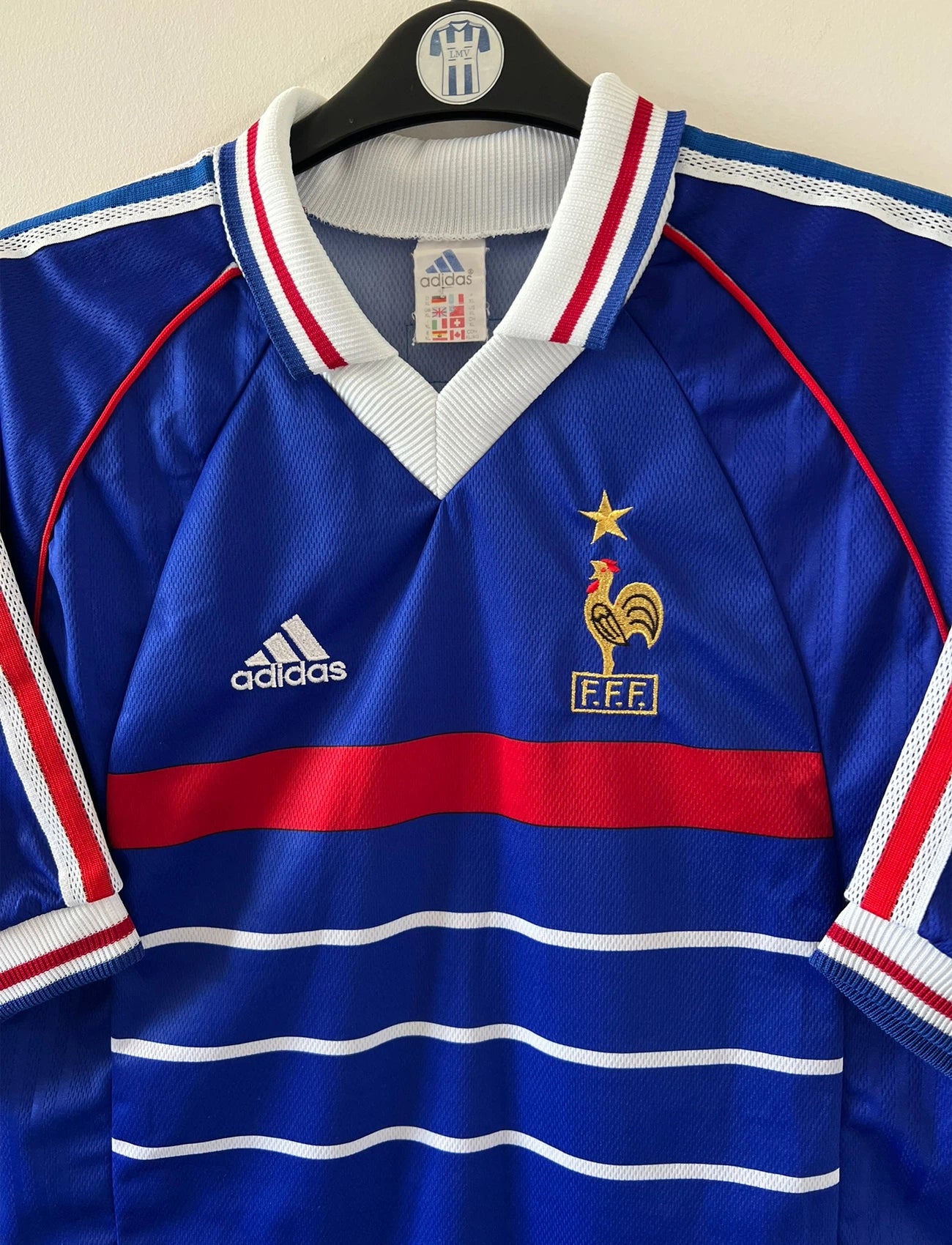 Maillot de foot vintage domicile bleu de l'équipe de france 1998. On peut retrouver l'équipementier Adidas. Le maillot est floqué du numéro 10 Zinedine Zidane. Il s'agit d'un maillot authentique d'époque.