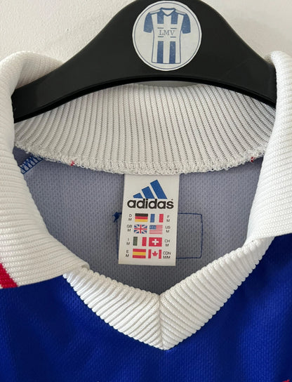 Maillot de foot vintage domicile bleu blanc et rouge de l'équipe de france 1998. On peut retrouver l'équipementier Adidas. Il s'agit d'un maillot authentique d'époque.