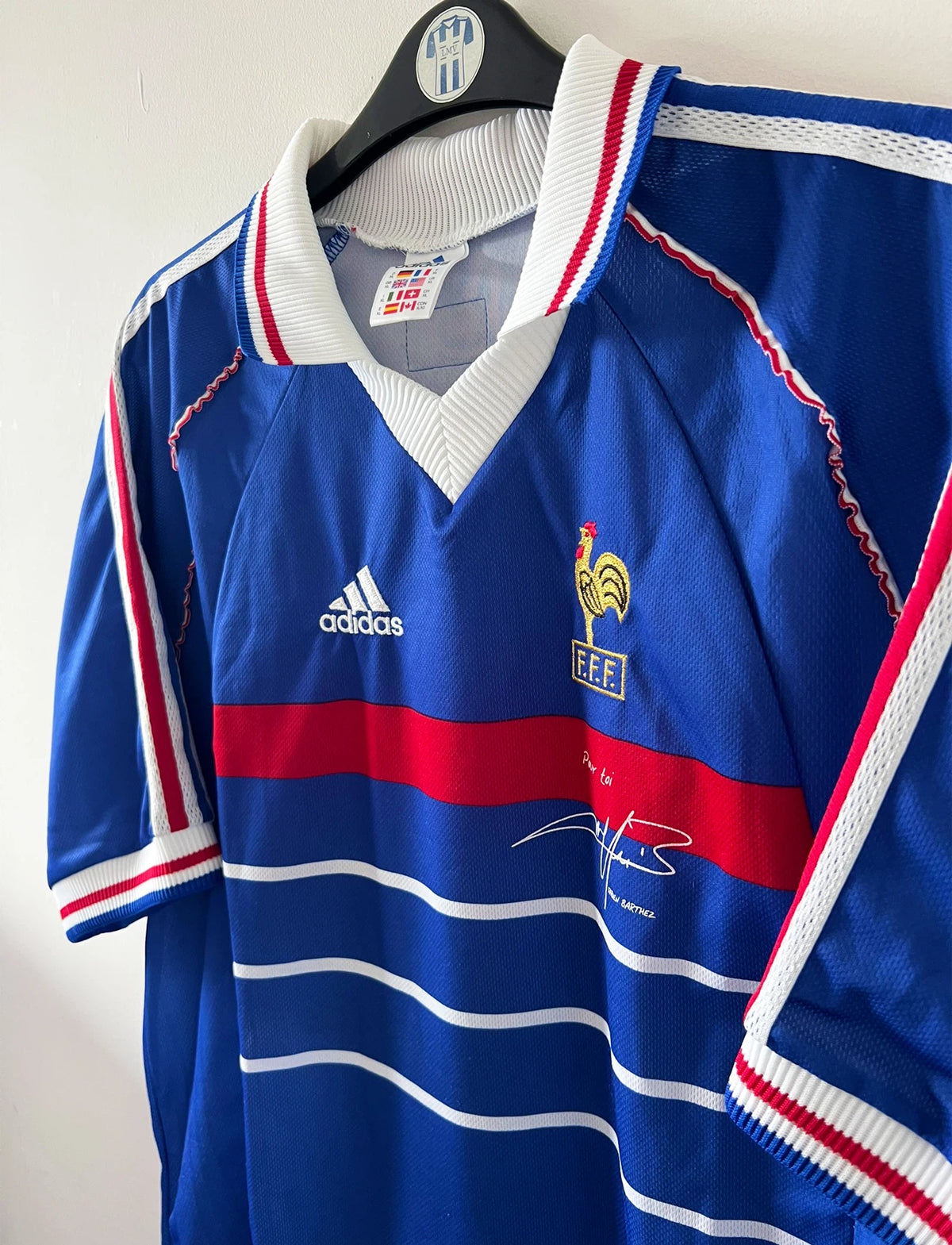Maillot de foot vintage domicile bleu de l'Equipe de France 1998. On peut retrouver l'équipementier Adidas. Il s'agit d'un maillot authentique d'époque avec la signature "pour toi Fabien Barthez".