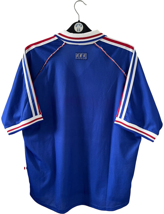 Maillot de foot vintage domicile bleu de l'Equipe de France 1998. On peut retrouver l'équipementier Adidas. Il s'agit d'un maillot authentique d'époque avec la signature "pour toi Fabien Barthez".