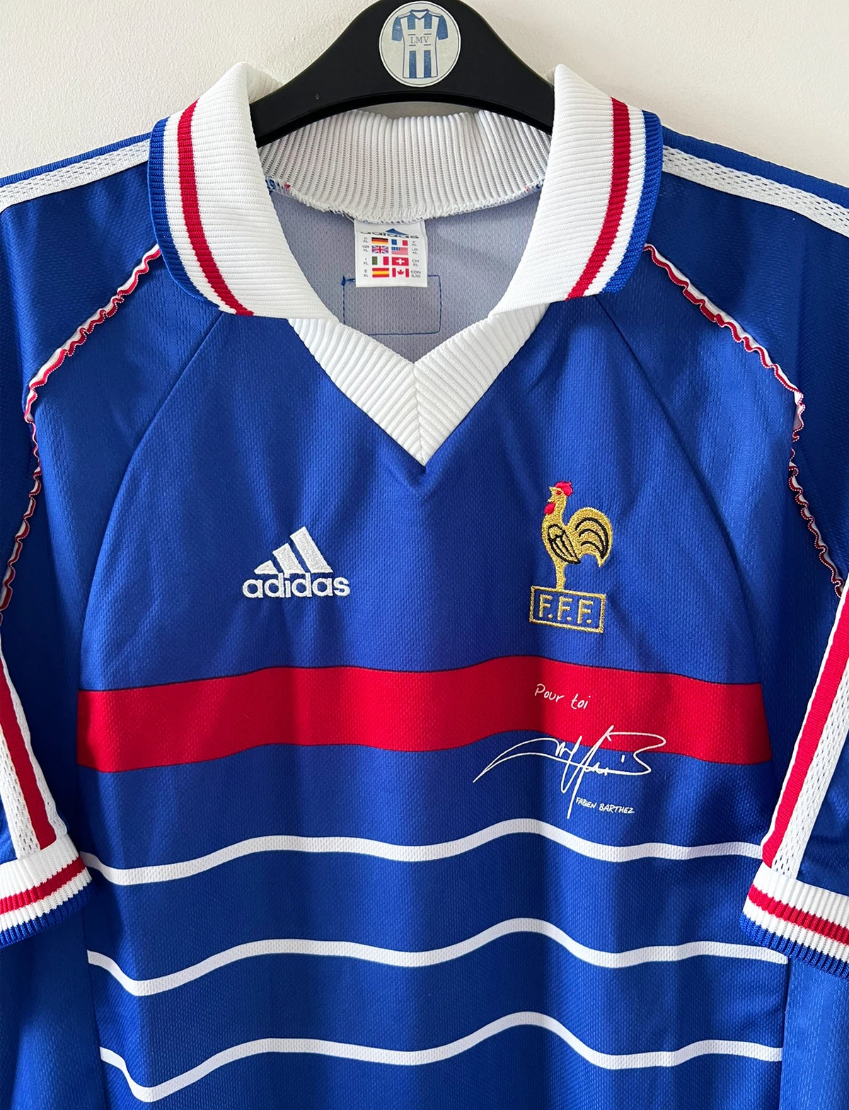 Maillot de foot vintage domicile bleu de l'Equipe de France 1998. On peut retrouver l'équipementier Adidas. Il s'agit d'un maillot authentique d'époque avec la signature "pour toi Fabien Barthez".