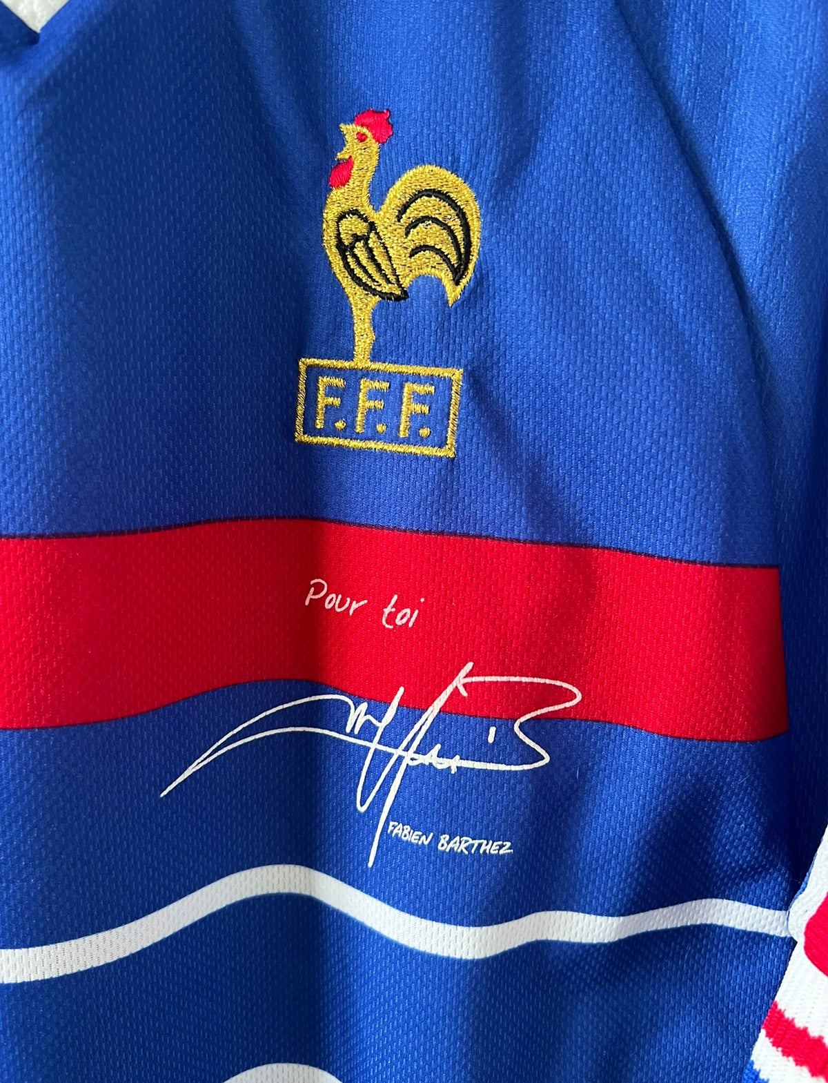 Maillot de foot vintage domicile bleu de l'Equipe de France 1998. On peut retrouver l'équipementier Adidas. Il s'agit d'un maillot authentique d'époque avec la signature "pour toi Fabien Barthez".