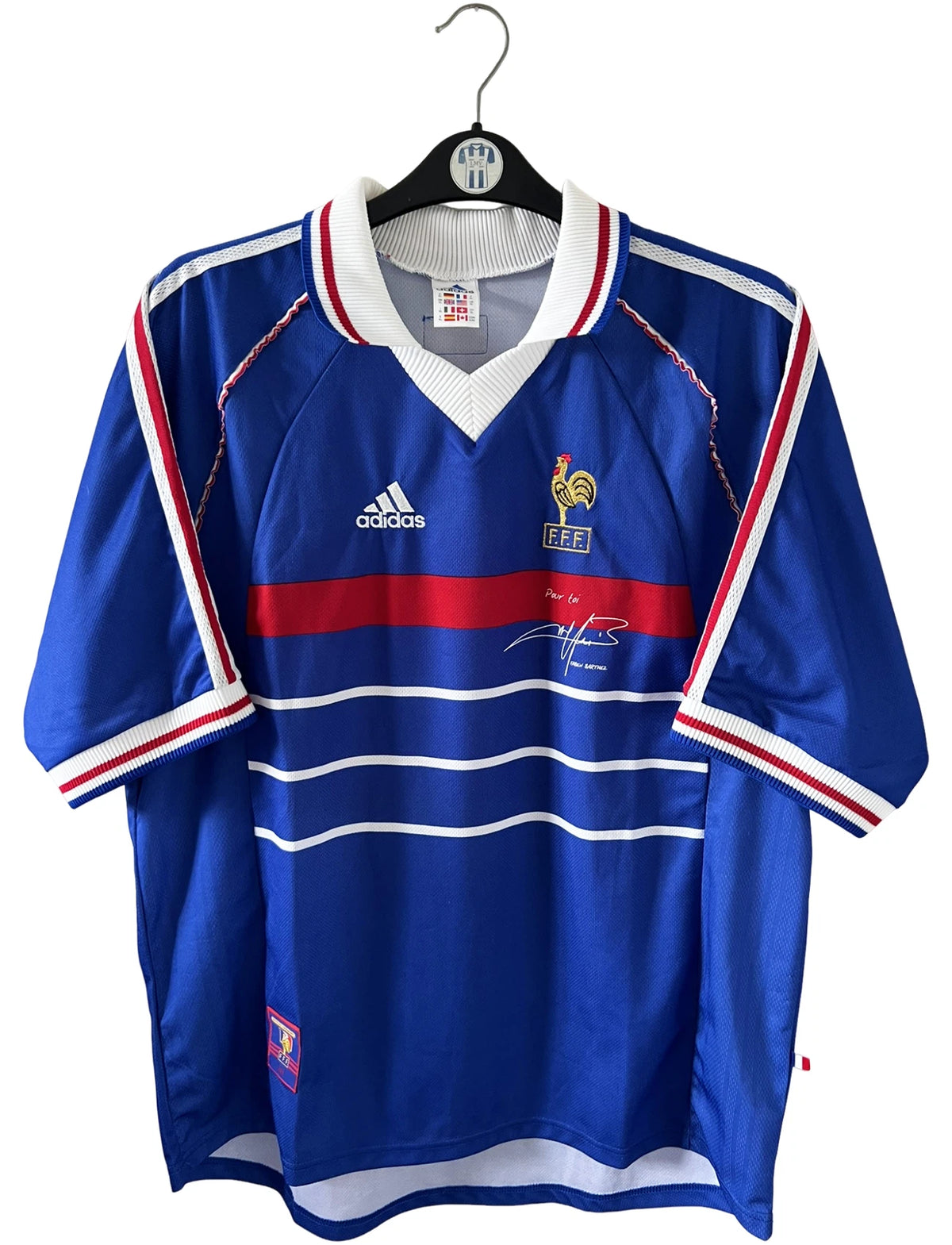 Maillot de foot vintage domicile bleu de l'Equipe de France 1998. On peut retrouver l'équipementier Adidas. Il s'agit d'un maillot authentique d'époque avec la signature "pour toi Fabien Barthez".