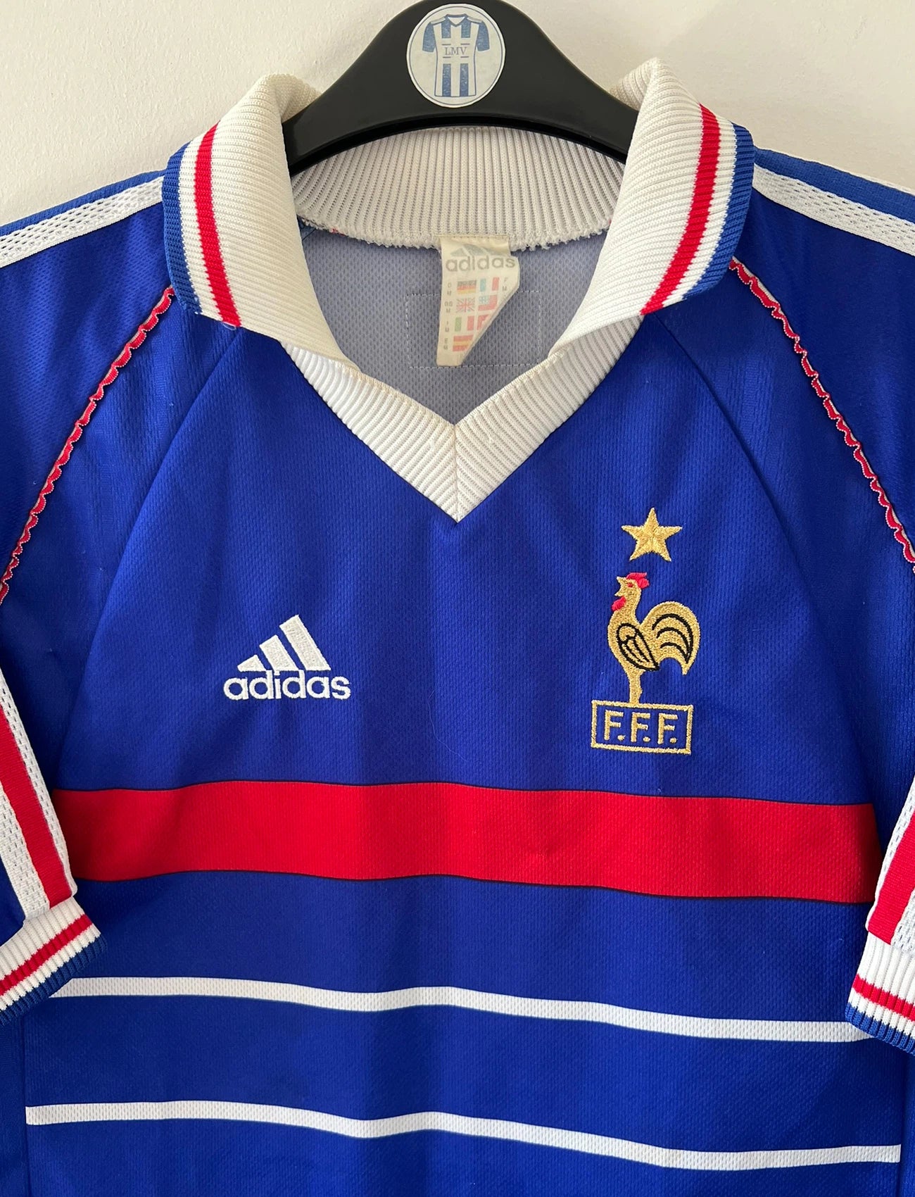 Maillot de foot vintage domicile bleu de l'équipe de France 1998. On peut retrouver l'équipementier Adidas. Il s'agit d'un maillot authentique d'époque.
