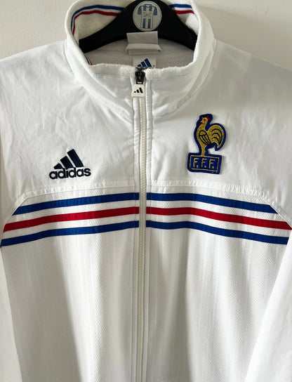 Veste de foot vintage blanche de l'Equipe de France 1998. On peut retrouver l'équipementier Adidas. Il s'agit d'un maillot authentique d'époque.